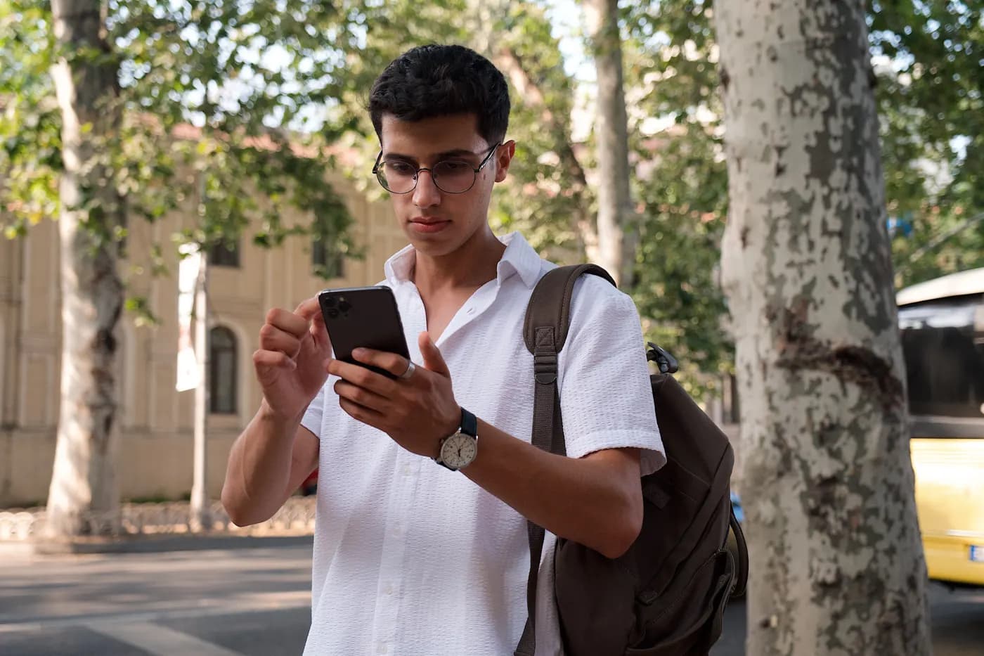 Young man browsing on his phone on the street